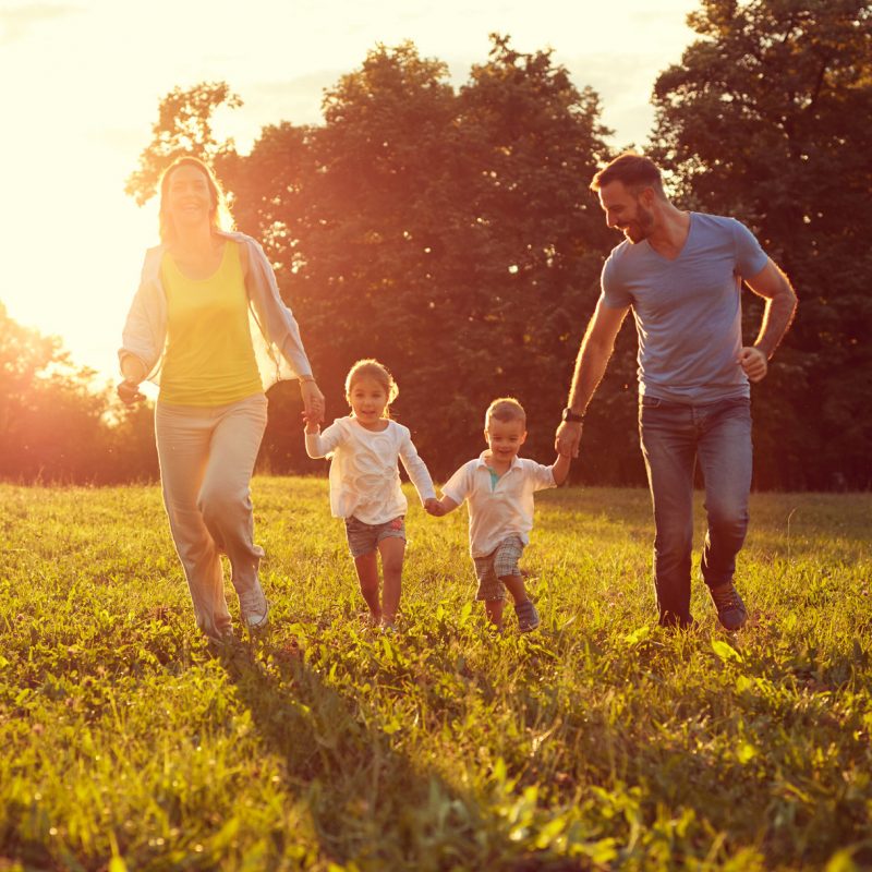 Happy children with parents running in park Happy young children with parents running in park